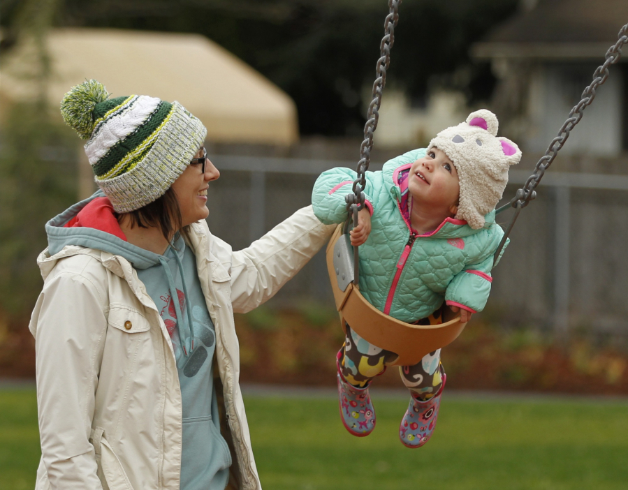 Sarah Bunn and her daughter Parker, 2, enjoy the swings Saturday as the Felida Neighborhood Association officially opens Sorenson Park.