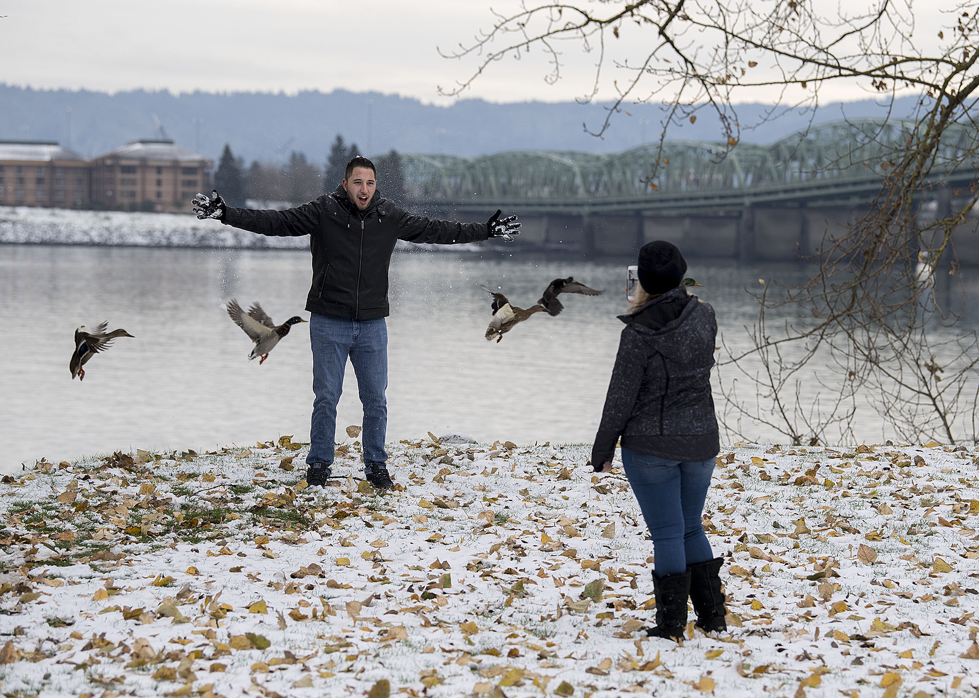 Zach Perez of Arizona, left, enjoys the winter weather as his girlfriend, Makayla Rehanek, snaps his photo while getting a surprise visit from a group of new feathered friends at the Vancouver Waterfront on Thursday afternoon, Dec. 15, 2016. The couple was in the Northwest housesitting and visiting family for the holidays.