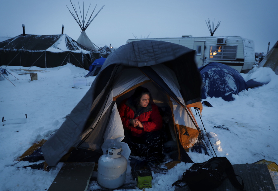 Karl McCartney, an Arrow Lakes Okanogan Native American from Omak, cleans snow out from his tent Monday after a storm blew through the Oceti Sakowin camp where people have gathered to protest the Dakota Access oil pipeline in Cannon Ball, N.D.