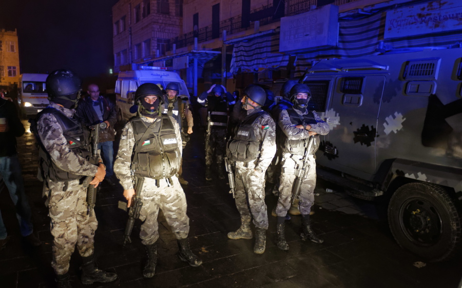 Jordanian security forces stand next to their armored vehicle at the scene next to Karak Castle, during an ongoing attack Sunday, in the central town of Karak, about 87 miles south of the capital Amman in Jordan.