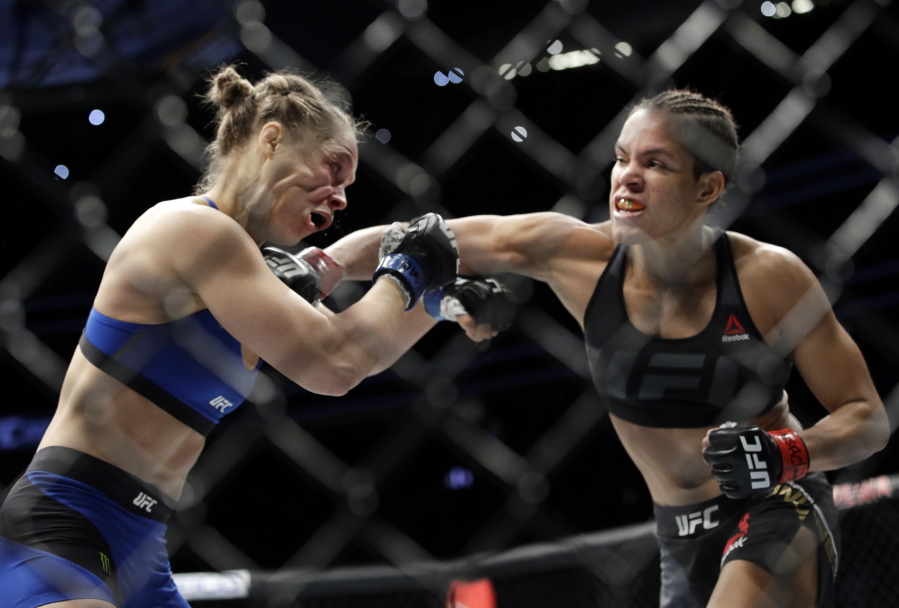 Amanda Nunes, right, connects with Ronda Rousey in the first round of their women&#039;s bantamweight championship mixed martial arts bout at UFC 207, Friday, Dec. 30, 2016, in Las Vegas. Nunes won the fight after it was stopped in the first round.
