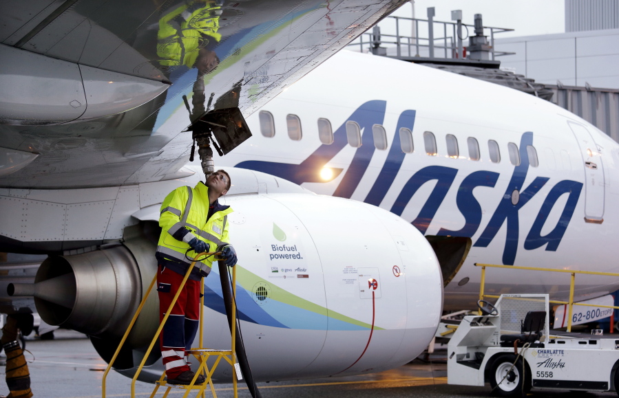 Fueling manager Jarid Svraka fuels an Alaska Airlines Boeing 737-800 jet Nov. 14 at Seattle-Tacoma International Airport in SeaTac. On Tuesday, Alaska Airlines said it has won government approval to buy rival Virgin America.