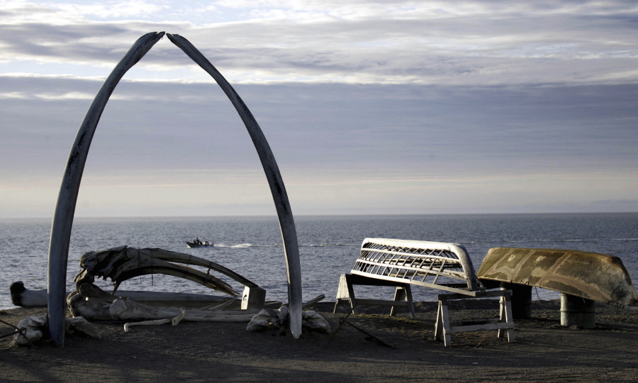 A boat drives past a skin boat display in 2005 near whale bones and an arch made of a whale jaw on the beach in a town that was known as Barrow, Alaska. Residents voted in October to change the name of their city to the Inupiaq name of Utqiagvik.