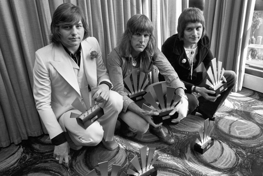 FILE - This is a Sept. 30, 1972  file photo of  the members of the rock band Emerson, Lake and Palmer,Greg Lake, left Keith Emerson, centre, and Carl Palmer after an award ceremony in London . Greg Lake, the prog-rock pioneer who co-founded King Crimson and Emerson, Lake and Palmer, has died. He was 69. Lake died Wednesday Dec, 7, 2016 after &quot;a long and stubborn battle with cancer,&quot; according to his manager.