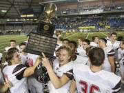 Camas team members celebrate with the trophy after they defeated  Richland in the 4A State Football Championship game Saturday, Dec. 3, 2016, in Tacoma.