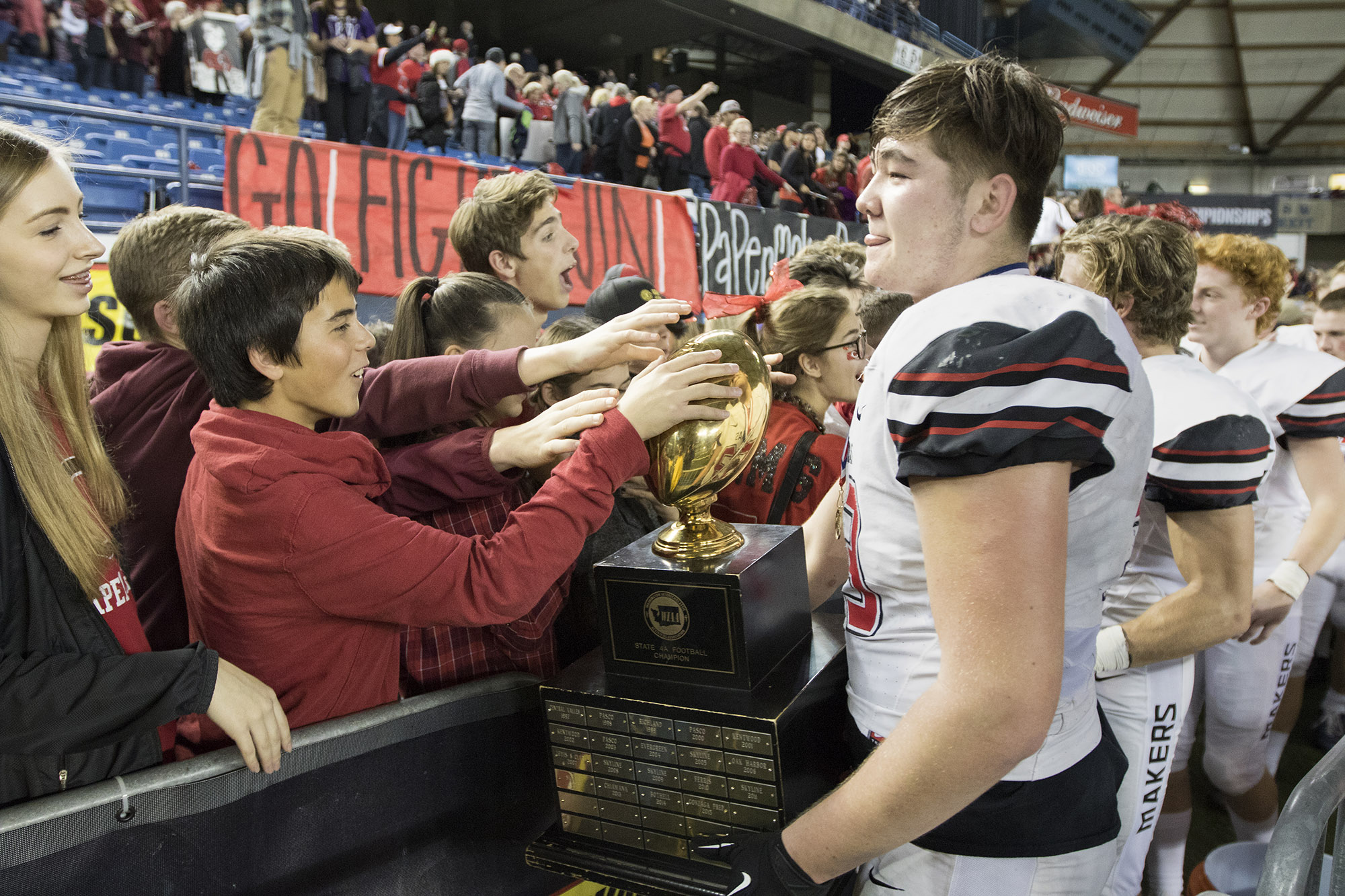 Camas' Marshall McIvor, right, brings the trophy to the Camas fans after Camas defeated  Richland in the 4A State Football Championship game Saturday, Dec. 3, 2016,  in Tacoma, Wash.