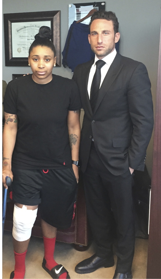 Marc Eli Freund stands next to his client Katrina Williams at the law firm&#039;s offices in New York, as she recovers from injuries she said says she got from an exploding e-cigarette.   (Lipsig, Shapey, Manus &amp; Moverman P.C.