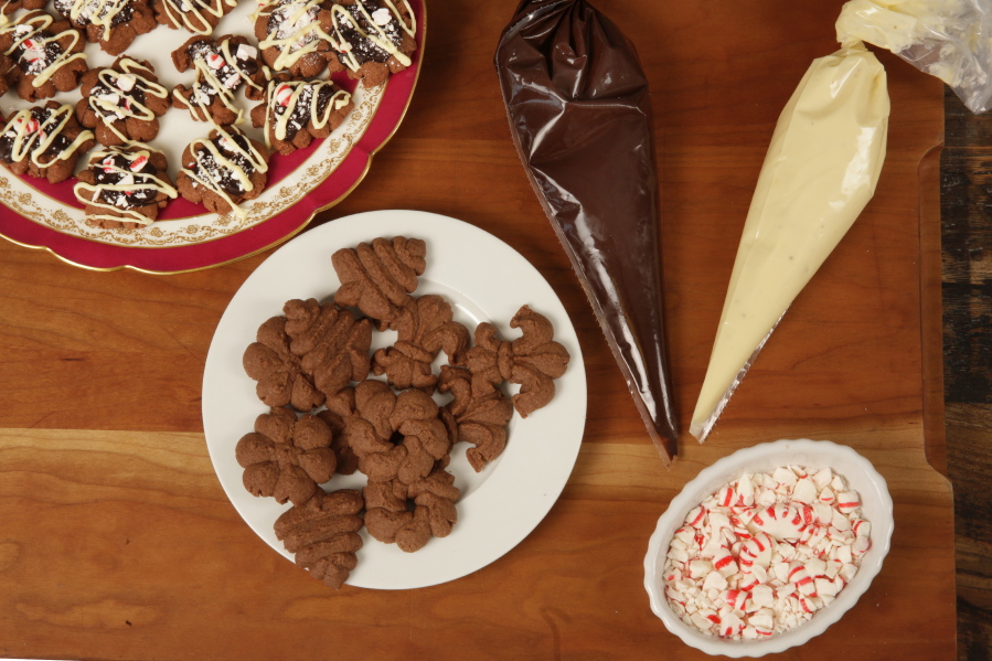 Pastry bags with white and dark chocolate and crushed candy are used to frost Peppermint Bark Spritz Cookies, from a recipe by Elizabeth Karmel, at the Institute of Culinary Education in New York.