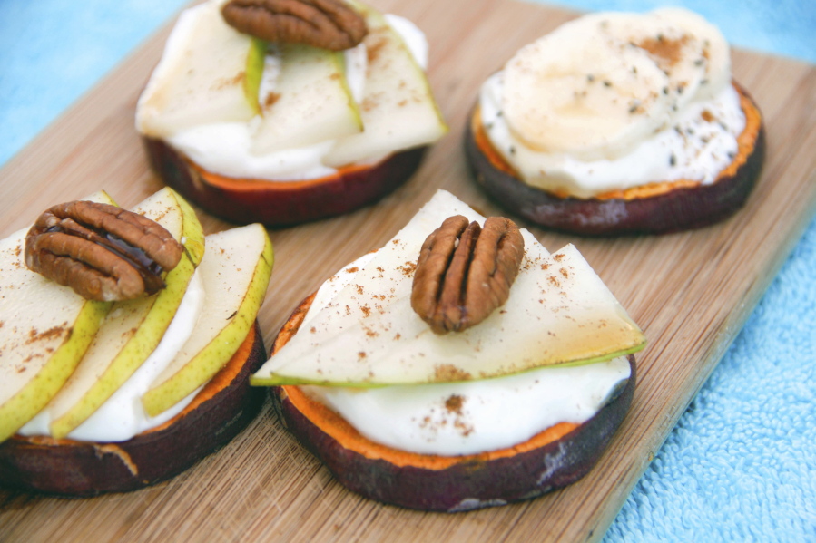 Sweet potato toasts made with slices of sweet potato, covered with pear and yogurt and topped with a pecan.