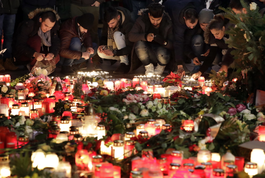 People light candles close to a Christmas market beside the memorial church in Berlin, Germany, Wednesday, Dec. 21, 2016, two days after a truck ran into a crowded Christmas market and killed several people.