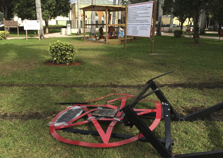 A pentagram erected by atheist Preston Smith lies damaged Tuesday in Sanborn Square in Boca Raton, Fla. Smith erected the pentagram earlier this month to protest a Nativity scene placed in the city-owned square.