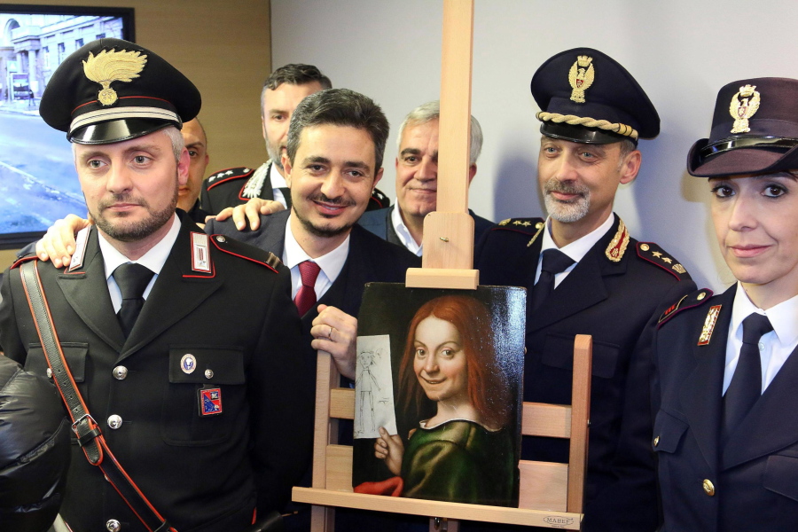 Carabinieri and police officers pose with one of the recovered paintings that were stolen  from a Verona museum, at the Verona airport, Italy, Wednesday, Dec. 21, 2016. Italy???s culture minister has traveled to Kiev to recover 17 paintings,  including works by Tintoretto, Rubens and Mantegna, that were stolen from a Verona museum and recovered by Ukrainian law enforcement more than seven months ago. Culture Minister Dario Franceschini and Verona Mayor Flavio Tosi traveled to retrieve the paintings.