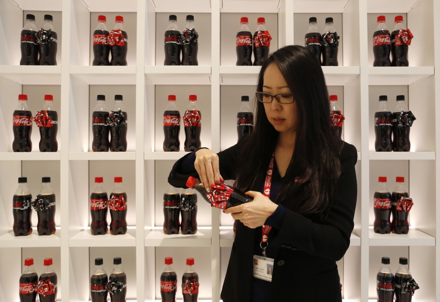 Kanako Kumazaki, group manager at Coca-Cola Japan, demonstrates the ribbons on the Coke bottles that are special for the holiday season at the Coca-Cola Japan office in Tokyo.