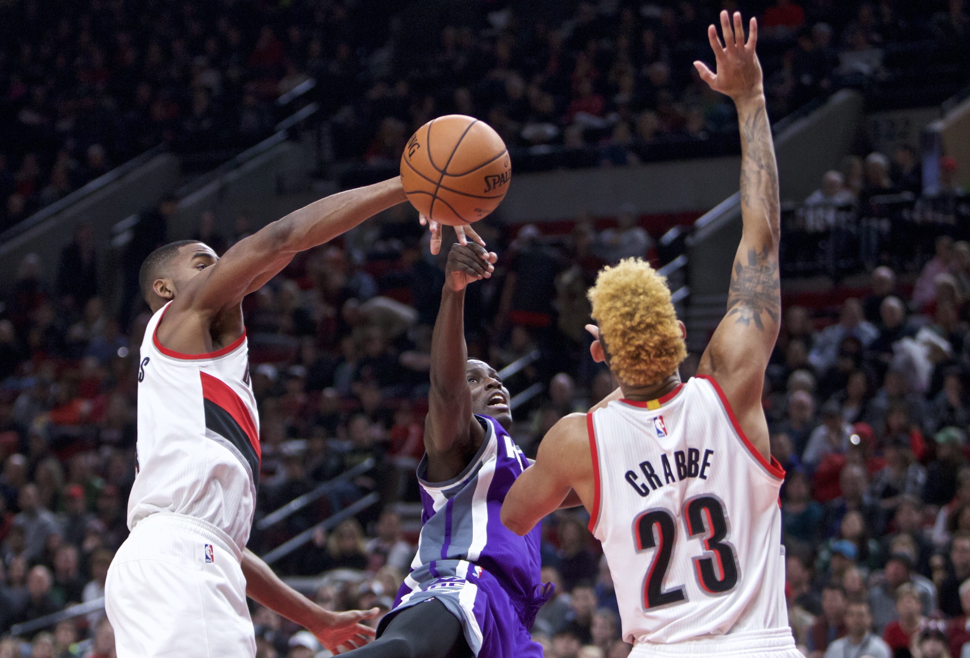 Sacramento Kings guard Darren Collison, center, has a shot knocked away by Portland Trail Blazers forward Maurice Harkless, left, as guard Allen Crabbe, right, defends during the first half of an NBA basketball game in Portland, Ore., Wednesday, Dec. 28, 2016.