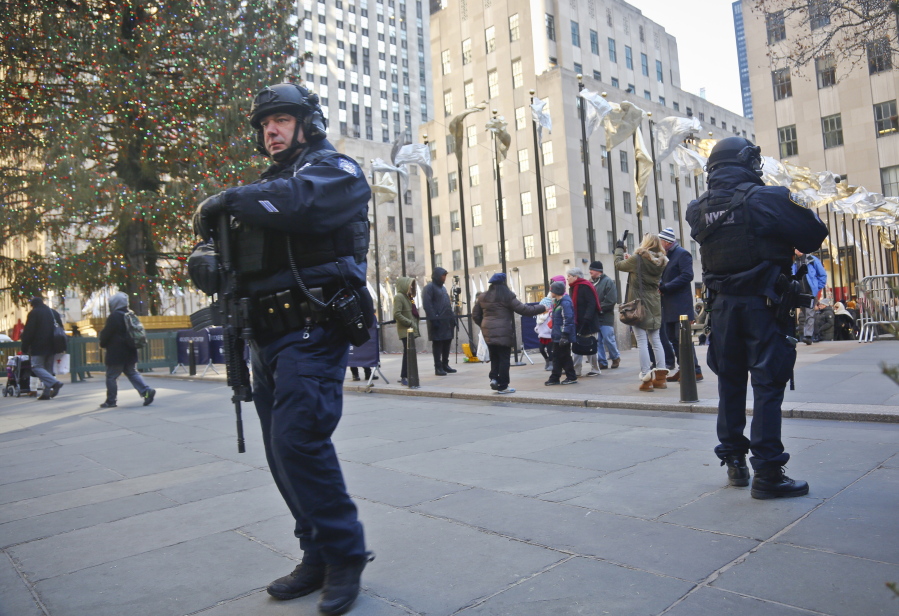 In this Dec. 20, 2016 file photo, New York City Police patrol near the Christmas tree at Rockefeller Center in New York. New York City Mayor Bill de Blasio says police are reinforcing various Christmas market locations around the city in the wake of the attack in Berlin, Germany that killed 12 people and wounded nearly 50 people.