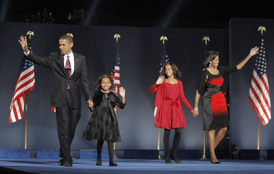 FILE - In this Nov. 4, 2008, file photo, then-President-elect Barack Obama, left, his wife Michelle Obama, right, and daughters, Malia, and Sasha, second from left, wave to the crowd at the election night rally in Chicago. (AP Photo/Jae C.
