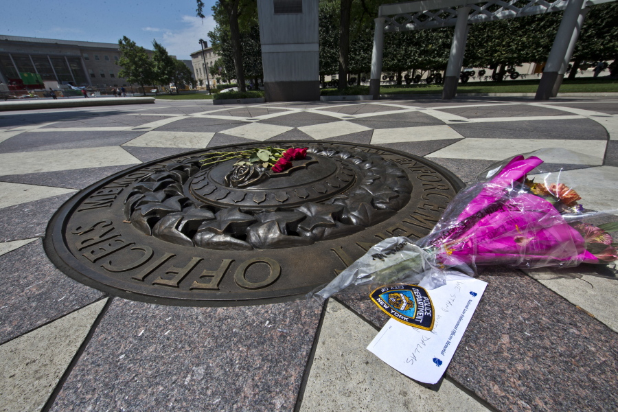 Five red roses rest on a bronze medallion along with another bouquet and a note of support for the Dallas Police Department on July 8 at The National Law Enforcement Officers Memorial in Washington. Five Dallas officers were killed by a sniper on July 7.
