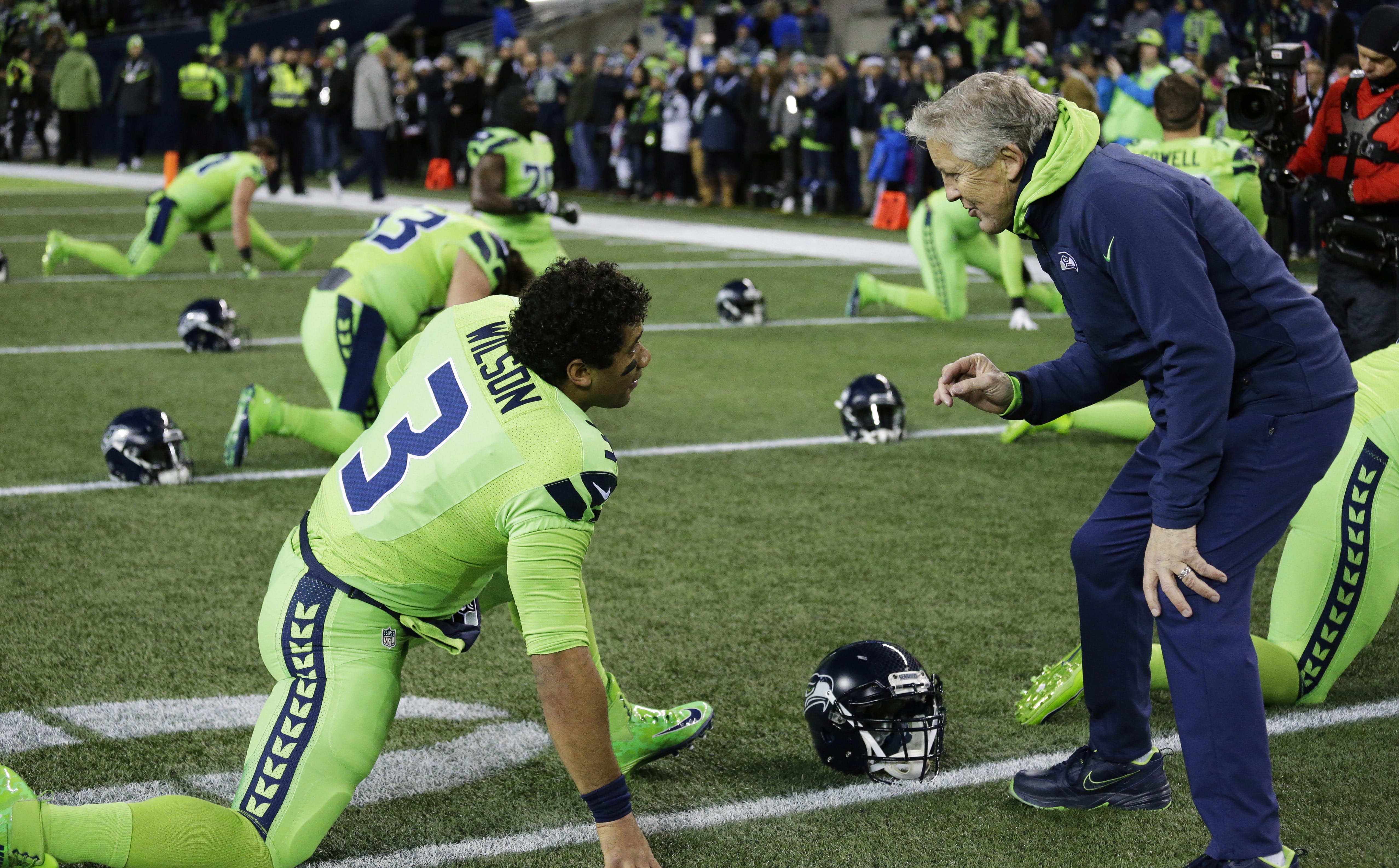 Seattle Seahawks head coach Pete Carroll, right, talks with quarterback Russell Wilson (3) before an NFL football game against the Los Angeles Rams, Thursday, Dec. 15, 2016, in Seattle.