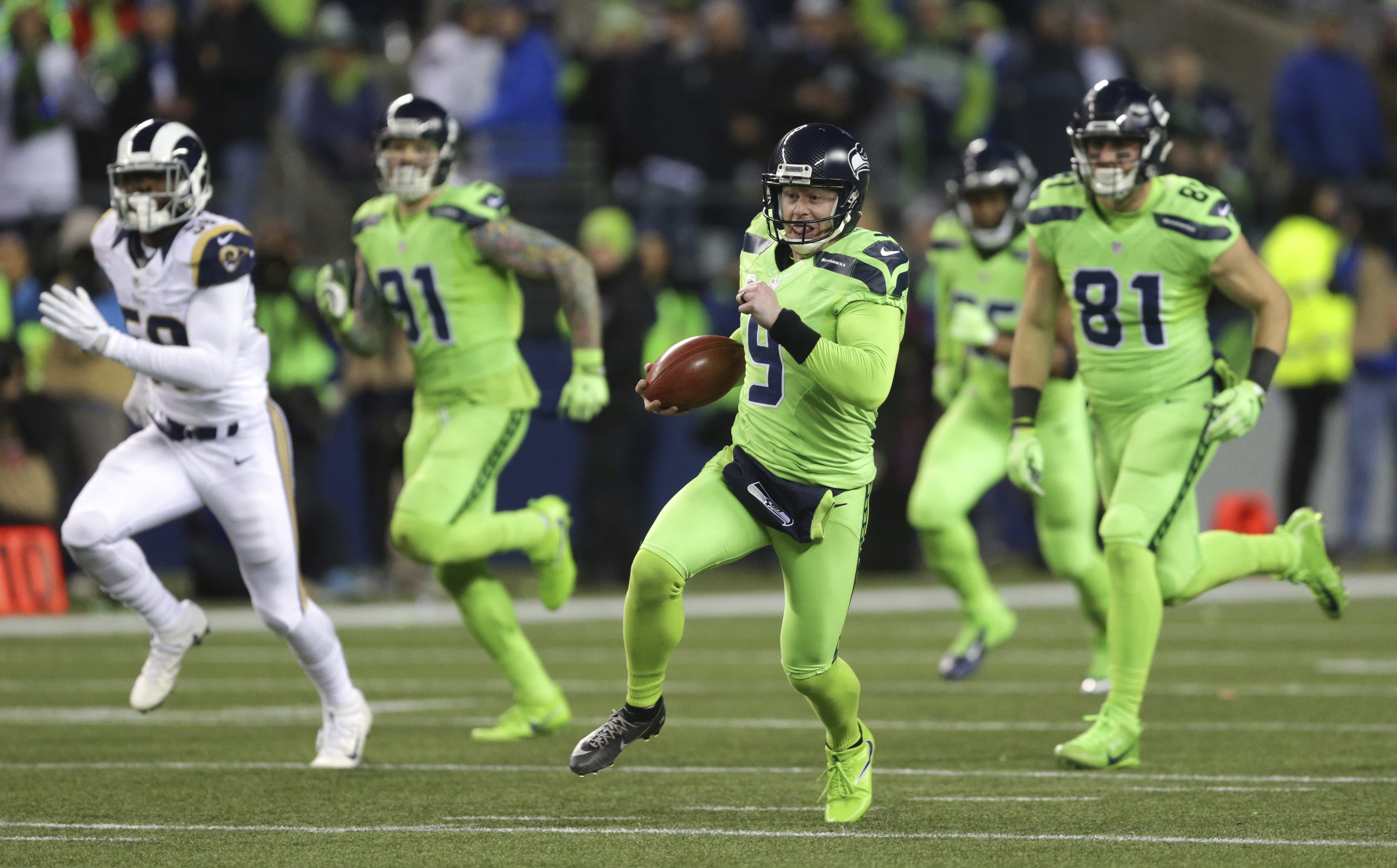 Seattle Seahawks punter Jon Ryan (9) runs the ball after a fake punt against the Los Angeles Rams in the second half of an NFL football game, Thursday, Dec. 15, 2016, in Seattle. Ryan suffered an injury on the play and left the game.