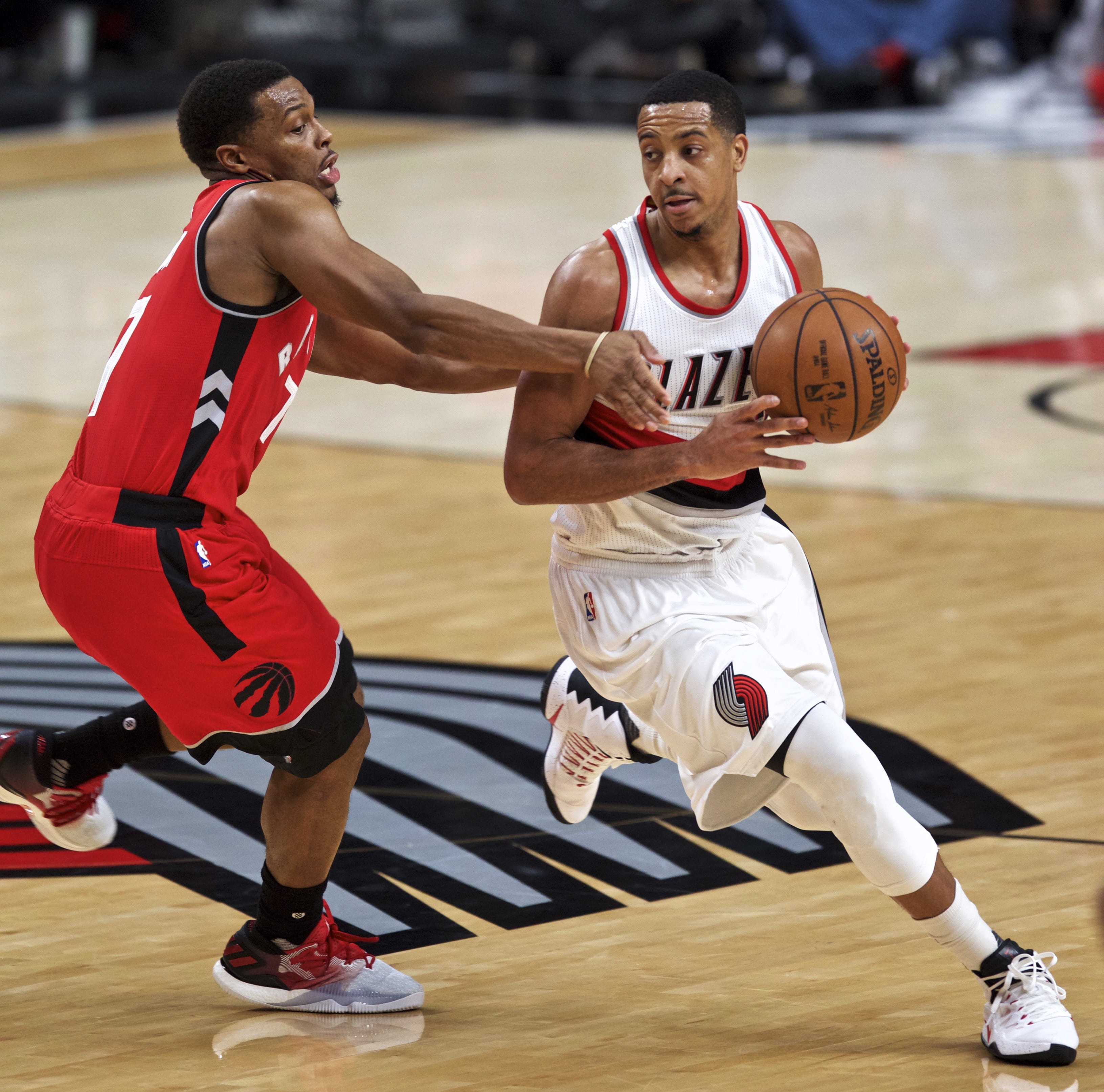 Portland Trail Blazers guard C.J. McCollum, right, dribbles around Toronto Raptors guard Kyle Lowry during the second half of an NBA basketball game in Portland, Ore., Monday, Dec. 26, 2016.