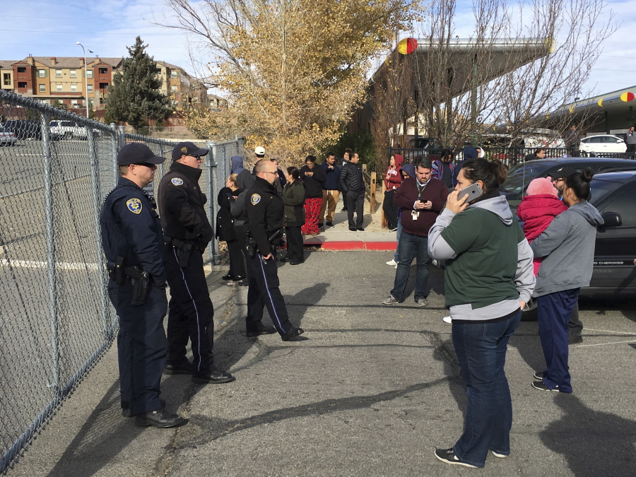 Parents wait outside Hug High School after a shooting on campus caused a lockdown, Wednesday, Dec. 7, 2016, in Reno, Nev.