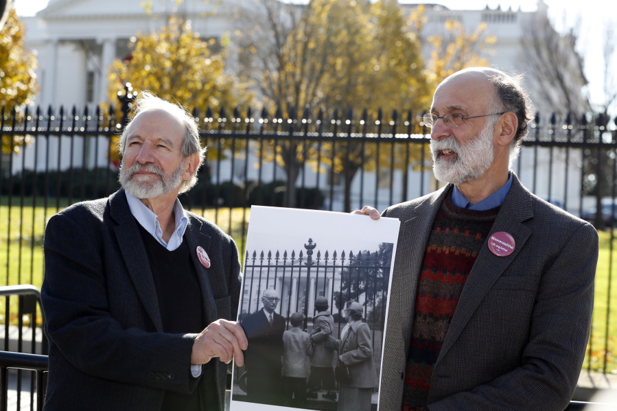 Michael, left, and Robert Meeropol, the sons of Ethel Rosenberg, stand Thursday in front of the White House with a photo of themselves as children in a similar spot.