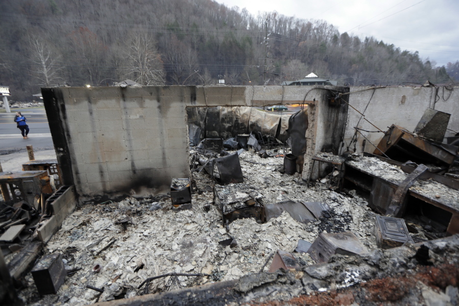 Some walls of a burned-out business remain Wednesday in Gatlinburg, Tenn., after a wildfire swept through the area Monday. People in cars and trucks rolled into the wildfire-ravaged city Friday to get a first look at what remains of their homes and businesses, and a mayor raised the death toll to 13, including a person who appeared to die of a heart attack while fleeing the flames.