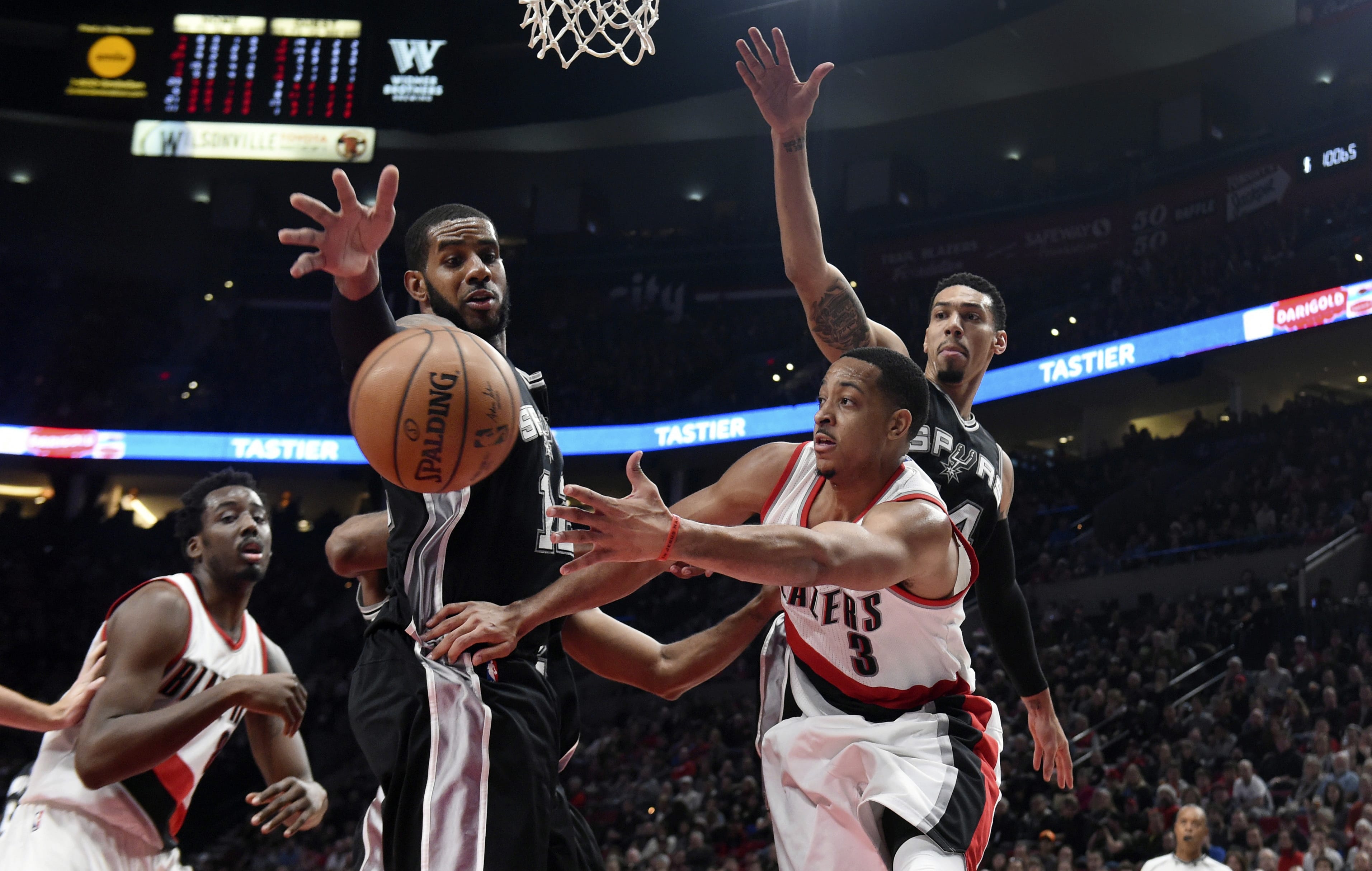 Portland Trail Blazers guard C.J. McCollum passes the ball as San Antonio Spurs forward LaMarcus Aldridge and guard Danny Green defend during the second half of an NBA basketball game in Portland, Ore., Friday, Dec. 23, 2016. The Spurs won 110-90.