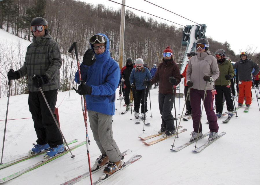 Skiers stand in a lift line Friday at Mad River Glen in Fayston, Vt., where 6 to 8 inches of new snow had fallen.