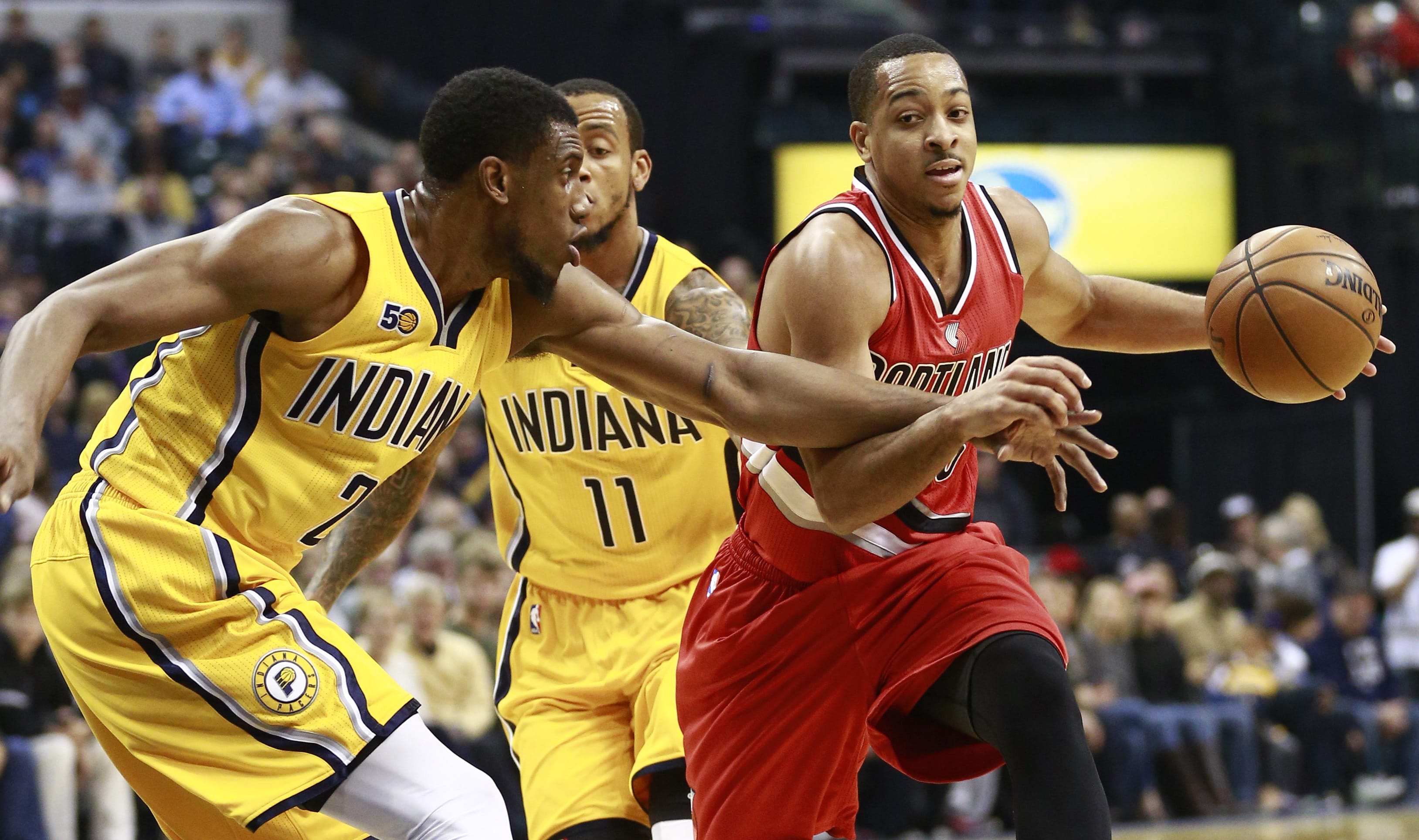 Indiana Pacers forward Thaddeus Young, left, gets a hand on Portland Trail Blazers guard C.J. McCollum, right, while Pacers guard Monta Ellis (11) trails the play in the first half of an NBA basketball game, Saturday, Dec. 10, 2016, in Indianapolis.