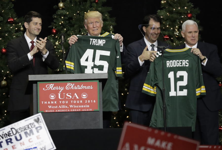 President-elect Donald Trump and Vice-President-elect Mike Pence hold up Green Bay Packers jerseys given to them by House Speaker Paul Ryan and Wisconsin Gov. Scott Walker at a rally Tuesday in West Allis, Wis.