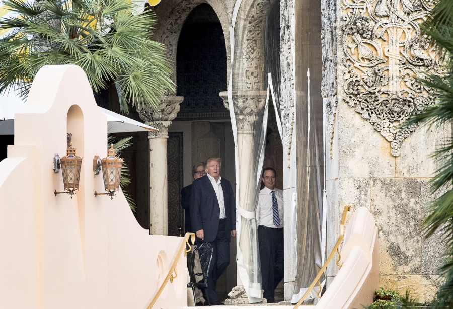 President-elect Donald Trump, second from right, chief strategist Steven Bannon, left, and Trump Chief of Staff Reince Priebus, right, walk along a balcony Monday at Mar-a-Lago resort, in Palm Beach, Fla. Trump is taking meetings today at the resort.