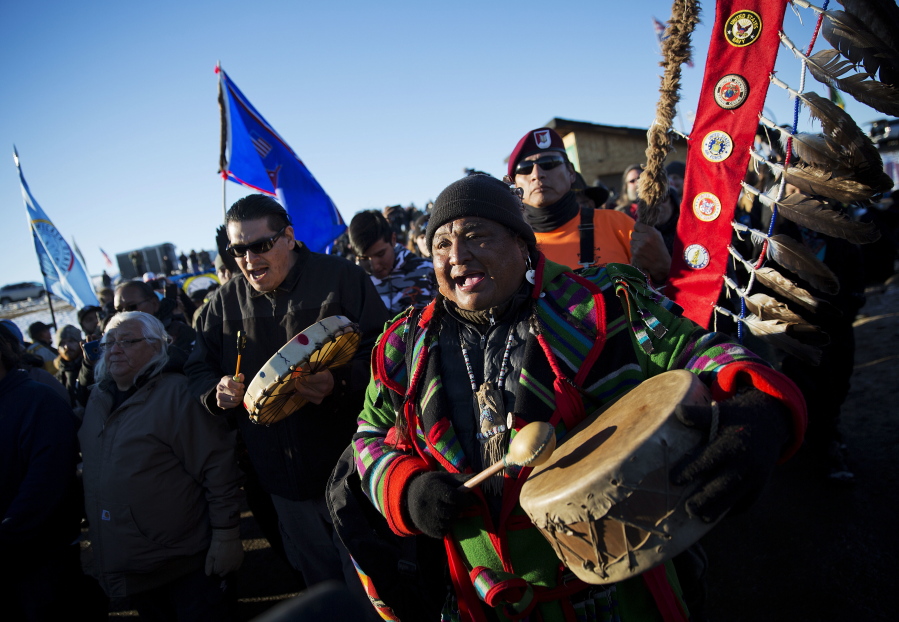 Dan Nanamkin, of the Colville Nez Perce Native American tribe in Nespelem, right, drums with a procession through the Oceti Sakowin camp Dec. 4 after it was announced that the U.S. Army Corps of Engineers won&#039;t grant easement for the Dakota Access oil pipeline in Cannon Ball, N.D.