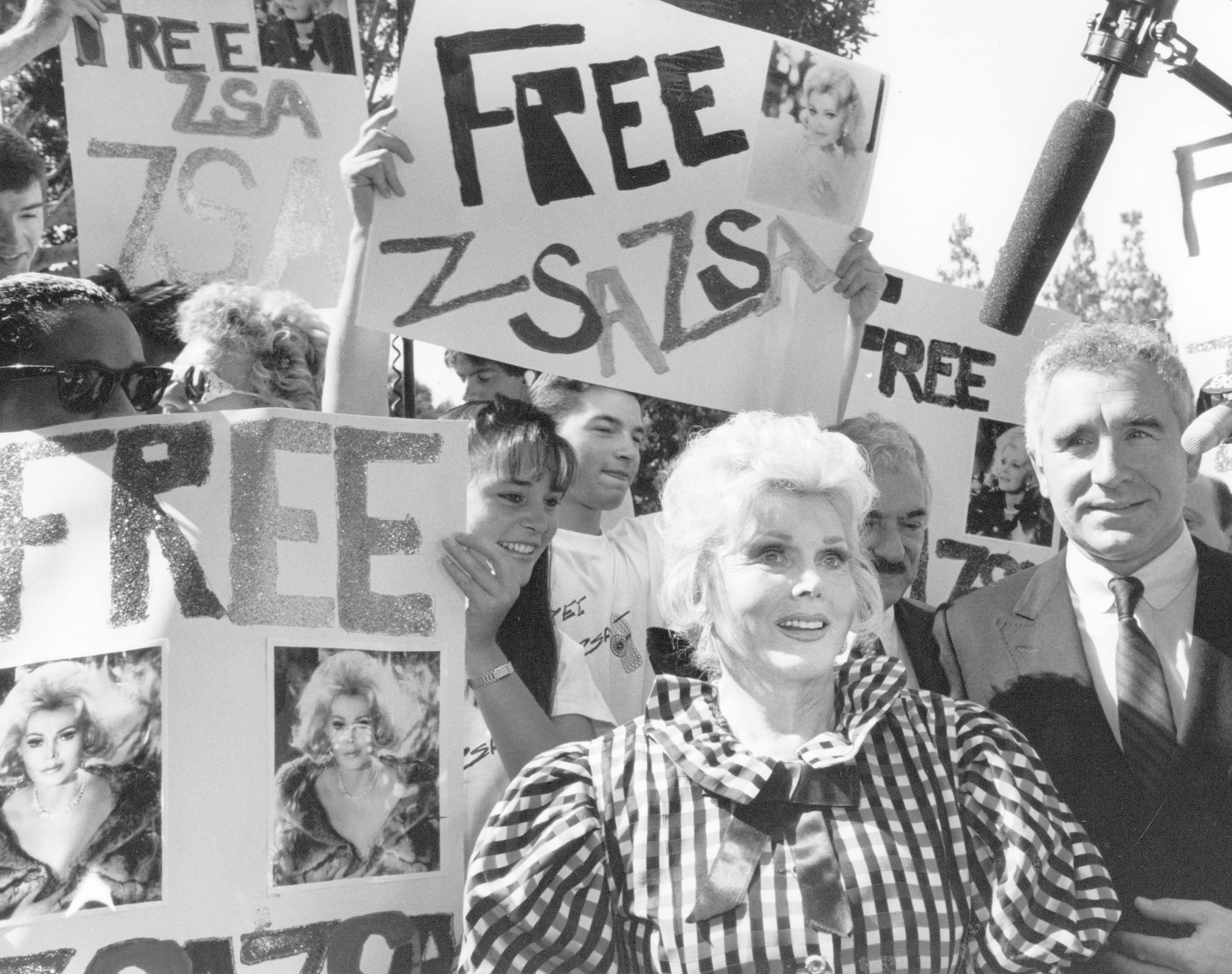 A 1989 staff file photo of Zsa Zsa Gabor arriving at court with husband, Prince Frederick von Anhalt, right, as fans show their support.