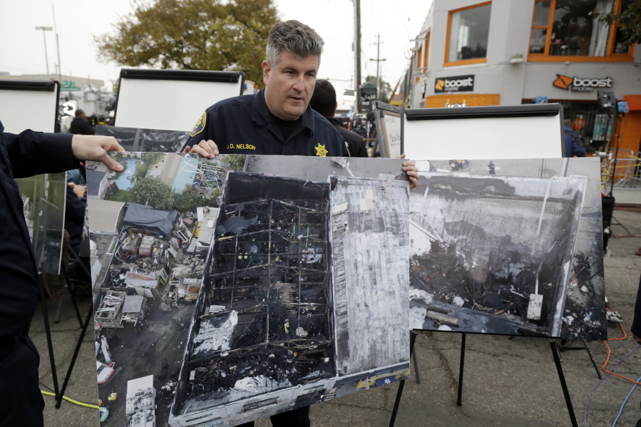 Alameda County Sheriff J.D. Nelson holds an aerial picture of a warehouse fire near the site Monday, Dec. 5, 2016, in Oakland, Calif. The death toll in the fire climbed Monday with more bodies still feared buried in the blackened ruins, and families anxiously awaited word of their missing loved ones. (AP Photo/Marcio Jose Sanchez) (jay l.