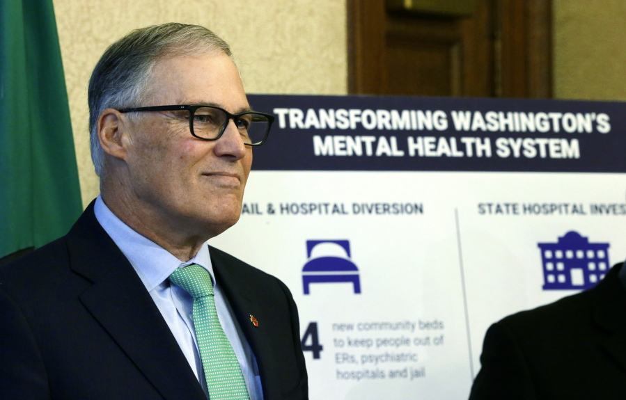 Gov. Jay Inslee stands next to a poster Wednesday as he waits to talk to reporters about his proposed budget in Olympia. While the bulk of Inslee&#039;s proposal focuses on education funding, his two-year plan also seeks more money for mental health and a tuition freeze for universities and community and technical colleges. (AP Photo/Ted S.