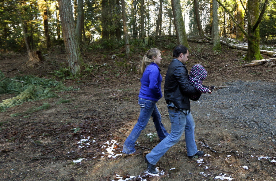 Bud Breakey and his wife, Deborah, walk with their 15-month-old daughter, Kaylin, on property they own near Bellingham. The couple hopes build a house and live on the land soon, but their plans were affected by a recent state Supreme Court ruling. (ted s.