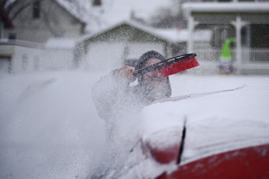 Steve Sarratt, of Sioux Falls, brushes snow from his car during a winter storm Friday in Sioux Falls, S.D. Winter storm warnings are in effect for much of the state. The National Weather Service says the storm will bring up to 8 inches of snow, wind gusts up to 25 mph and dangerous arctic air.