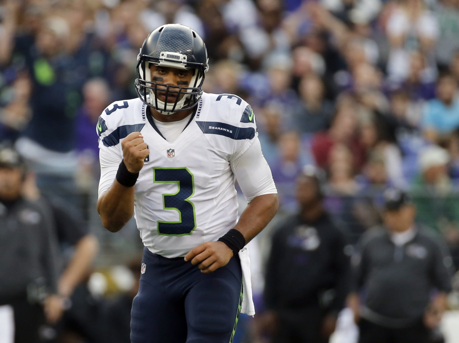 Seattle Seahawks quarterback Russell Wilson (3) celebrates a touchdown pass to Seahawks wide receiver Doug Baldwin during the second half an NFL football game against the Baltimore Ravens, Sunday, Dec. 13, 2015, in Baltimore.