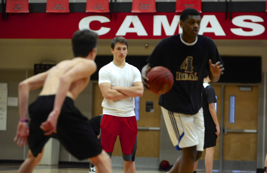 Jake Hansel, center, a Camas High School student who stays involved with the basketball team despite a heart defect which sidelined him, assists with a recent practice.