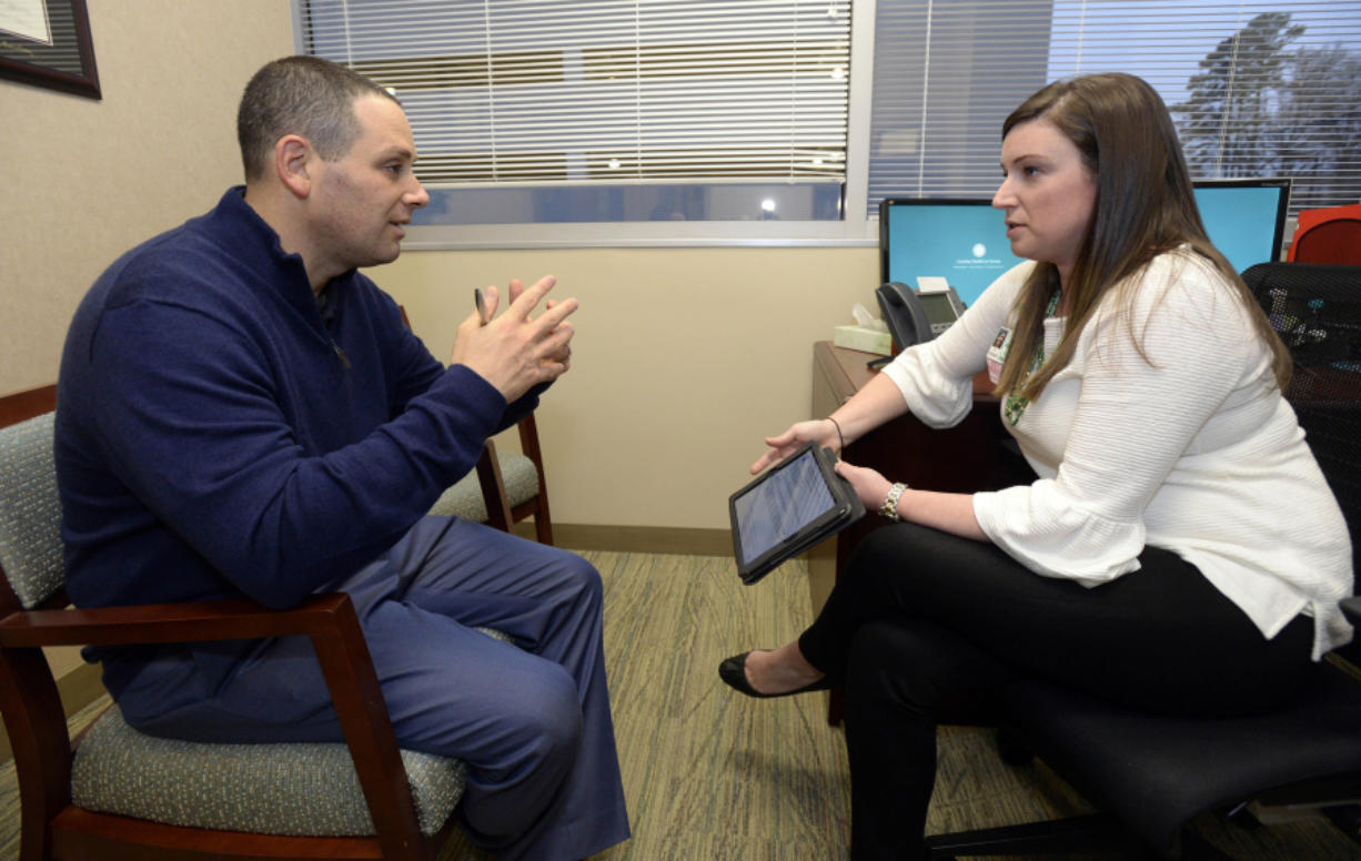 Dr. Jason Dranove discusses cancer treatment guidelines with genetic counselor Stacy Lenarcic at Carolinas HealthCare System&#039;s Levine Cancer Institute on Dec. 13 in Charlotte, N.C. Dranove, a doctor at Levine Children&#039;s Hospital, had breast tissue removed to prevent cancer that killed his uncle. (David T.