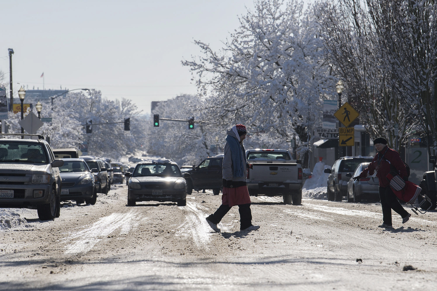 Pedestrians and motorists navigate a slushy, thawing Main Street in Uptown Village on Thursday afternoon.