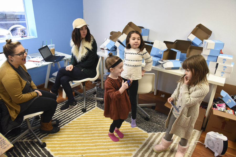 EggDrop leaders Miranda Bickford, from left, and Lauren Edmonds attempt to work in their Vancouver office while Edmonds&#039; daughters, Penny and Mya Edmonds, play with Bickford&#039;s daughter, Evelyn Bickford, far right, during another snow day Tuesday.
