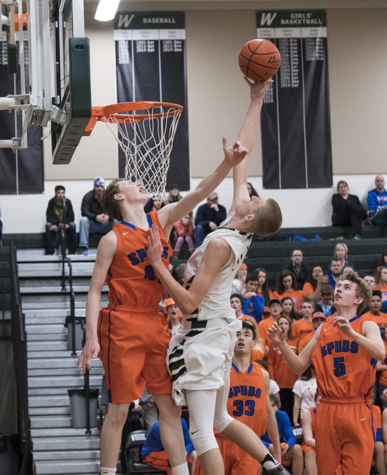 Woodland’s Bryce Mulder (0) makes a shot over Ridgefield’s Louden Wardius (43) during the second quarter at Woodland High School, Tuesday January 31, 2017.