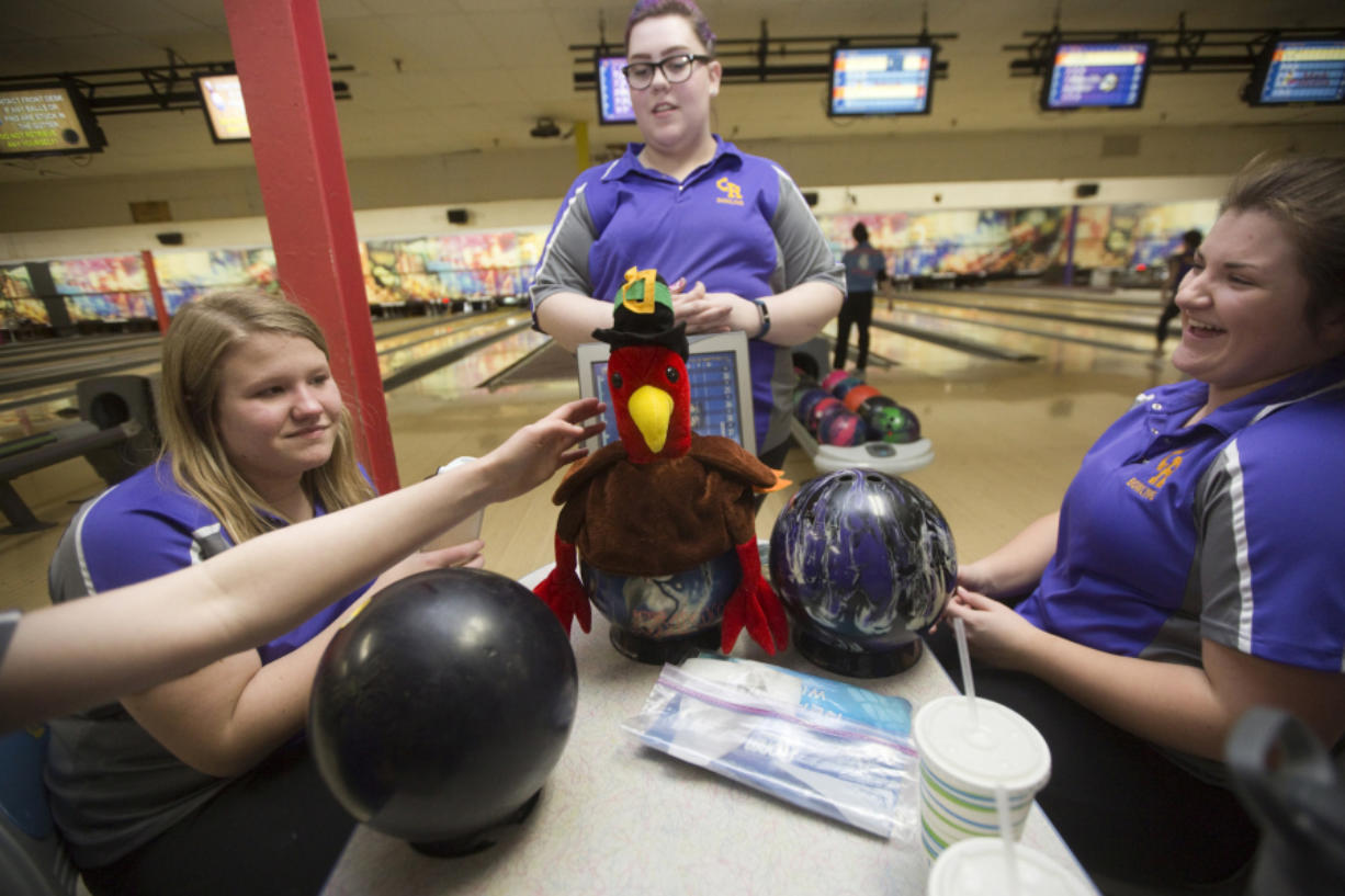 A turkey hat is placed on a bowling ball during a Columbia River bowling match as team members laugh (L to R) Jenika Taylor, Becca Gunderson and Maddy Getz, in Vancouver Monday January 23, 2017. When a player gets three strikes in a row, they get to wear a turkey hat.