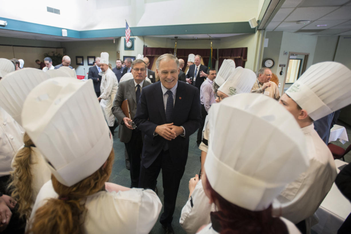 Gov. Jay Inslee, center, chats with culinary students during a &quot;Mini Inaugural Ball&quot; at Cascadia Technical Academy on Tuesday. The program&#039;s culinary students normally cater the Inaugural Ball but were unable to this year due to snow.