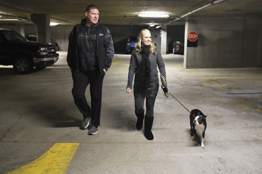 Dan Mitchell, left and Heidi Lee, vice president and president of the Esther Short Neighborhood Association, respectively, and downtown residents and business owners, walk through the Vancouvercenter garage. They and other downtown residents are upset by limited parking in the garage.