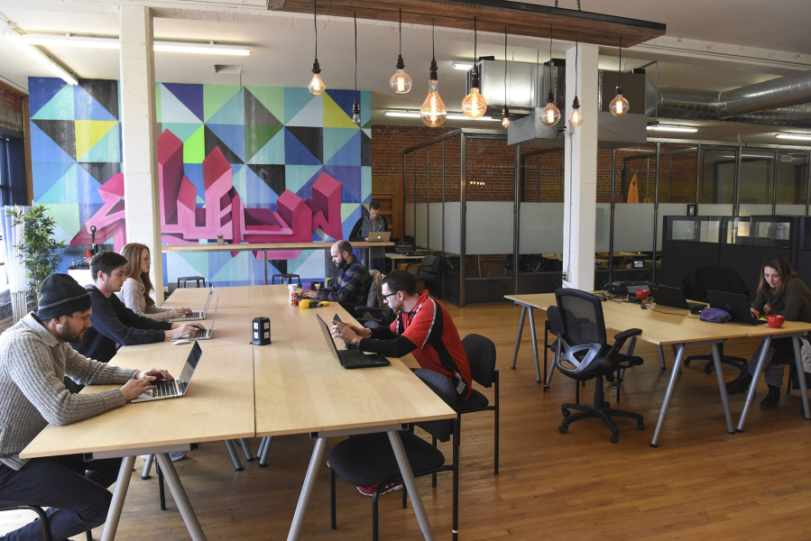 Members of Columbia Collective on Main Street in downtown Vancouver work on their computers. The co-working space expanded to larger offices in less than a year.