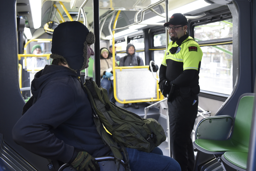 Ethan Greagor, left, talks with Max Wajda, a C-Tran fare compliance officer, while riding The Vine. The compliance officers will check for tickets, which are bought in advance, not from the driver.