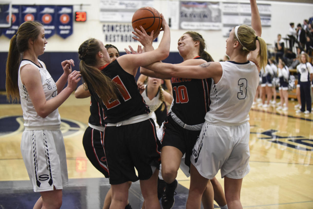 Camas’ Teague Schroeder (10) and Emma Jones (21) battle for control of the ball with Skyview’s Riley Friauf (3) during the second quarter Tuesday at Skyview High School, January 3, 2017.